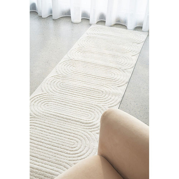 White modern runner rug with textured concentric arc pattern on a neutral background.