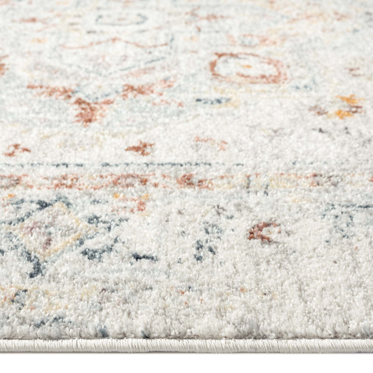 Cream runner rug with subtle traditional floral patterns in muted orange, blue, and grey tones.