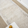 Beige and cream textured runner rug with subtle abstract patterns and distressed edges on hardwood floor.