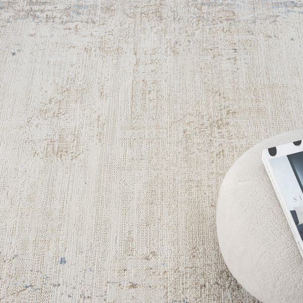 Beige textured abstract rug with subtle multi-colored accents in a soft, modern design.