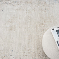 Beige textured abstract rug with subtle multi-colored accents in a soft, modern design.