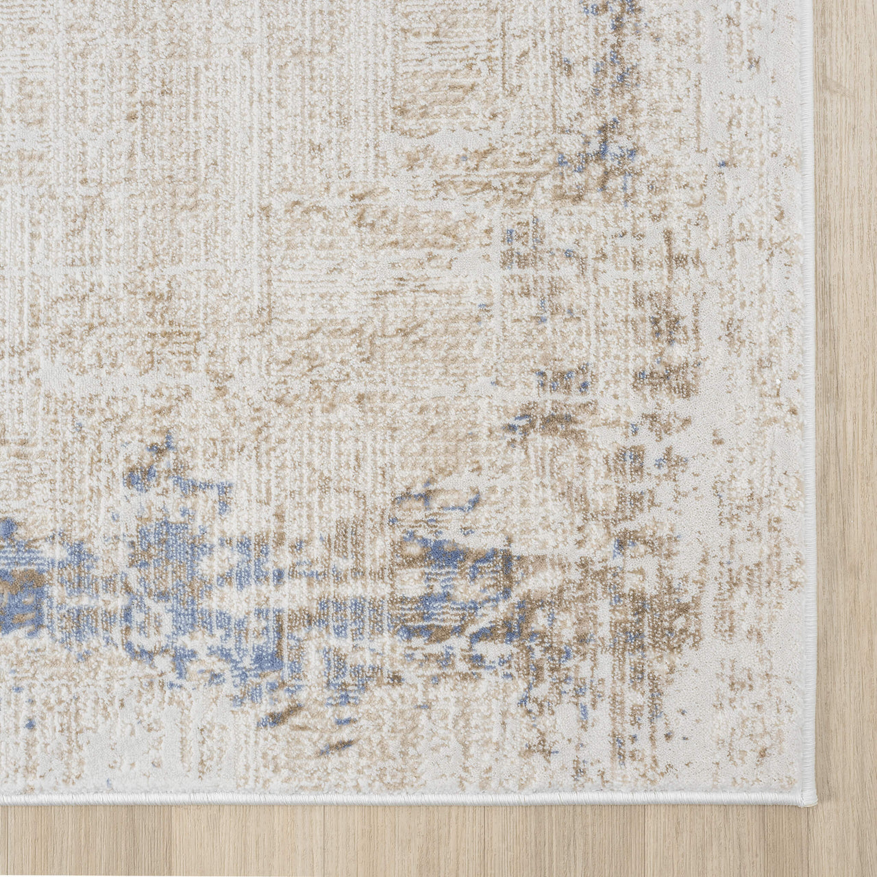 Beige textured rug with abstract multi-colored blue and taupe accents and soft woven fibers.