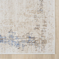 Beige textured rug with abstract multi-colored blue and taupe accents and soft woven fibers.