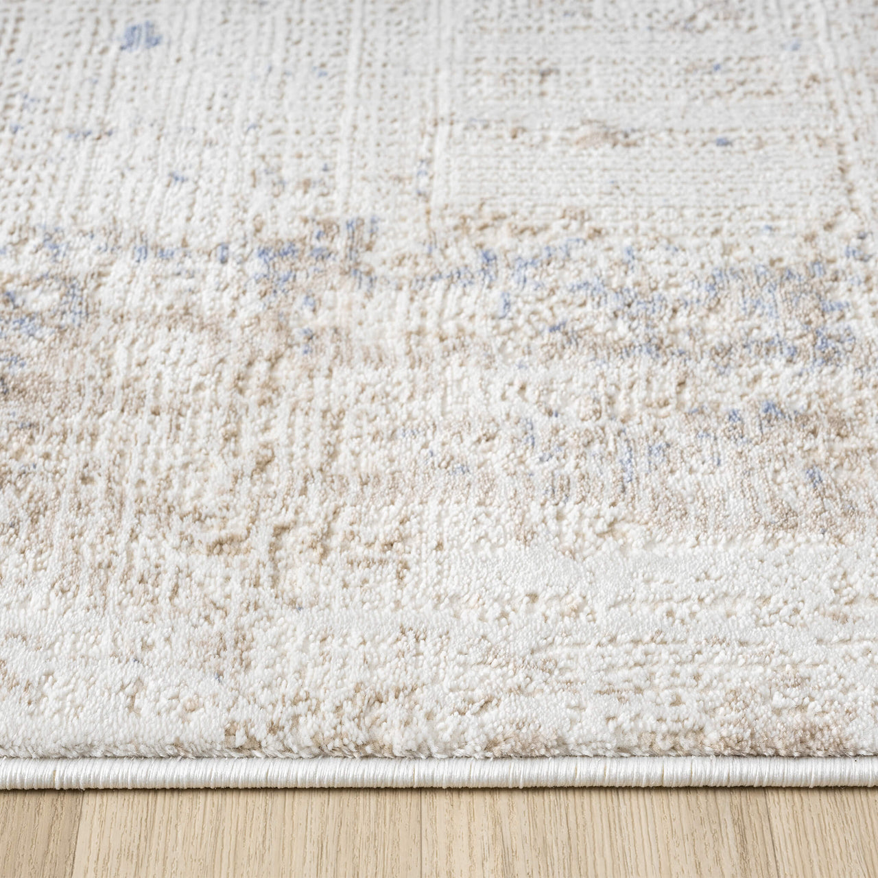 Beige and cream textured rug with subtle abstract patterns and a soft, plush pile.