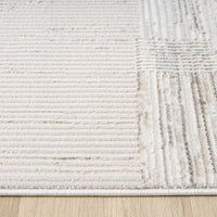 Beige and grey textured modern rug with striped and grid patterns on light background.