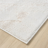 Close-up of beige and white modern rug corner with subtle textured pattern and clean edge on wooden floor.