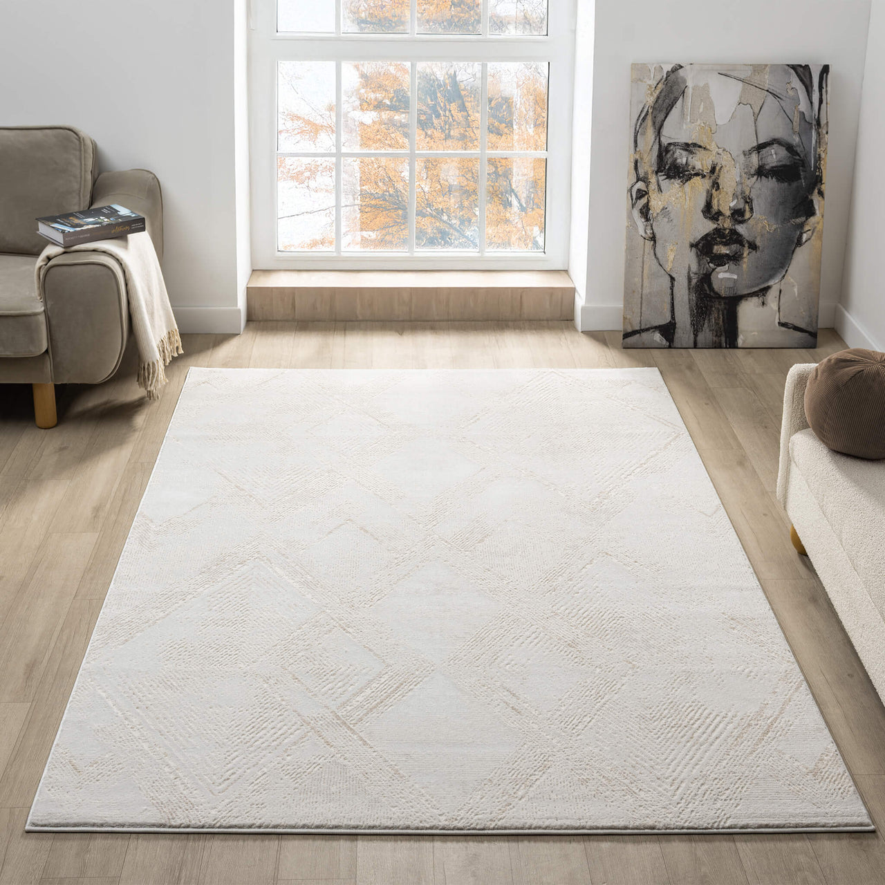 Beige and white modern rug with subtle geometric patterns on a light wood floor in a bright living room.