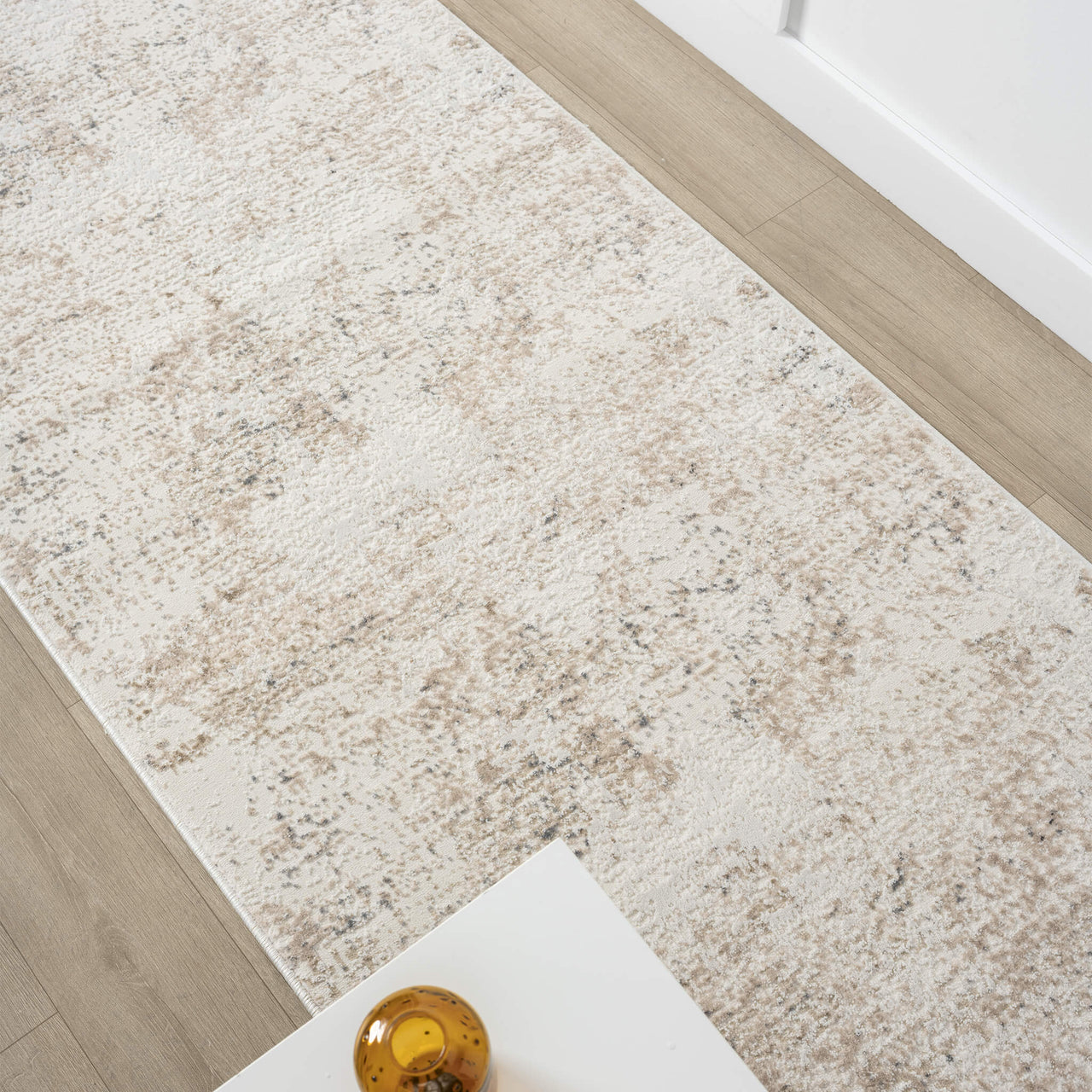 Beige and grey modern runner rug with subtle abstract pattern on hardwood floor.