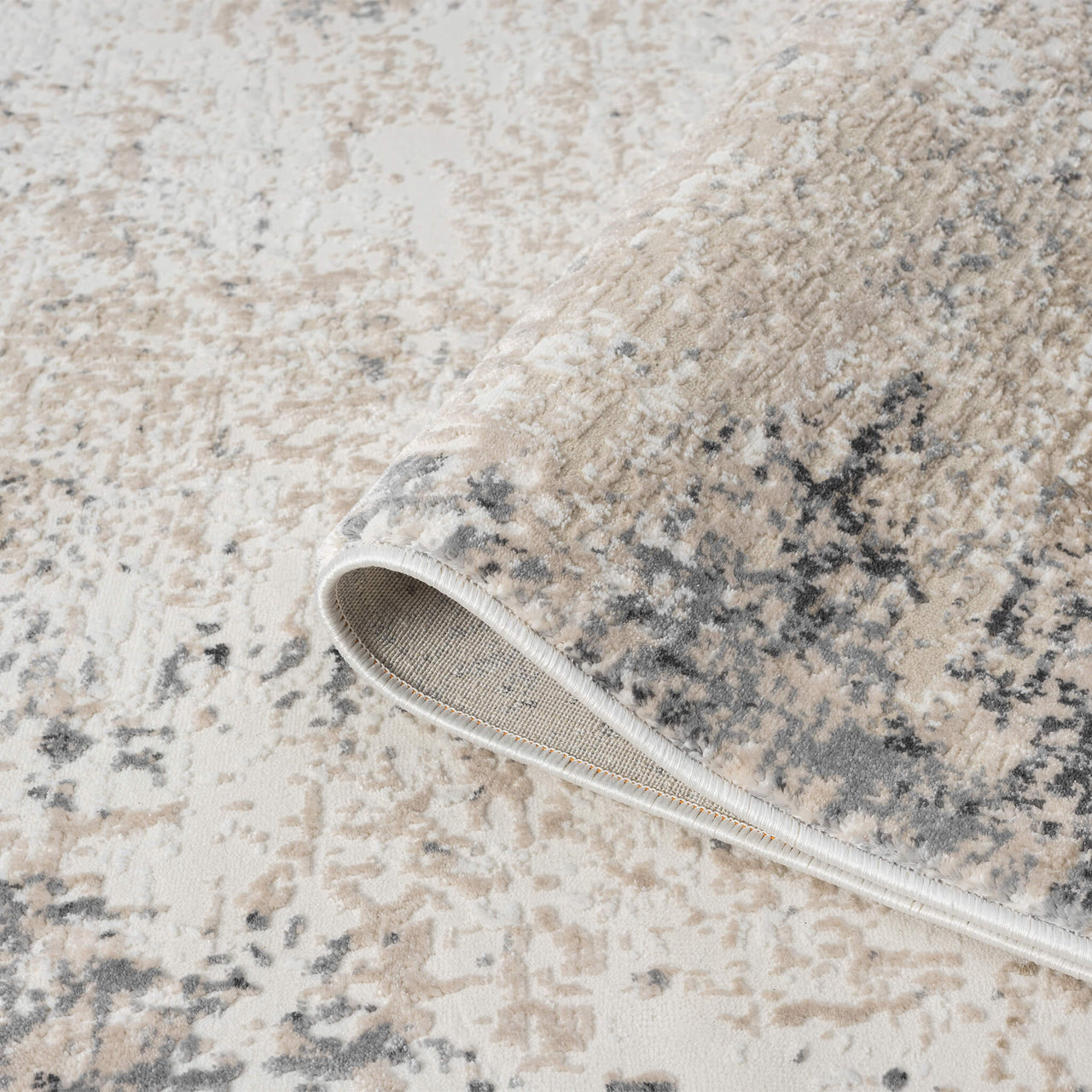 Beige and grey modern runner rug with abstract multi-color pattern and folded corner detail.