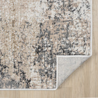 Beige and grey modern runner rug with abstract mottled pattern and piped edges on hardwood floor.