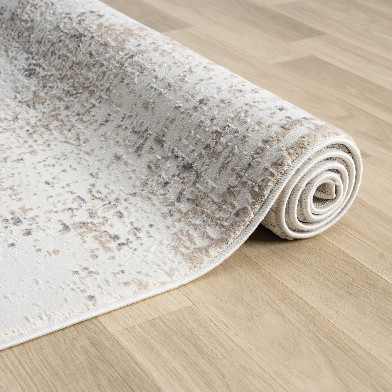 Rolled beige and grey modern runner rug with subtle abstract pattern on light wood floor.