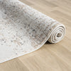 Rolled beige and grey modern rug with textured abstract pattern on light wood floor.