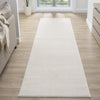 Cream modern runner rug with subtle textured pattern on light wood floor in bright hallway.