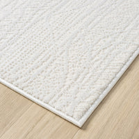 Cream modern rug with subtle textured geometric pattern and clean edges on wood floor.