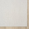 Cream modern rug with subtle geometric pattern and textured weave on light wood floor.