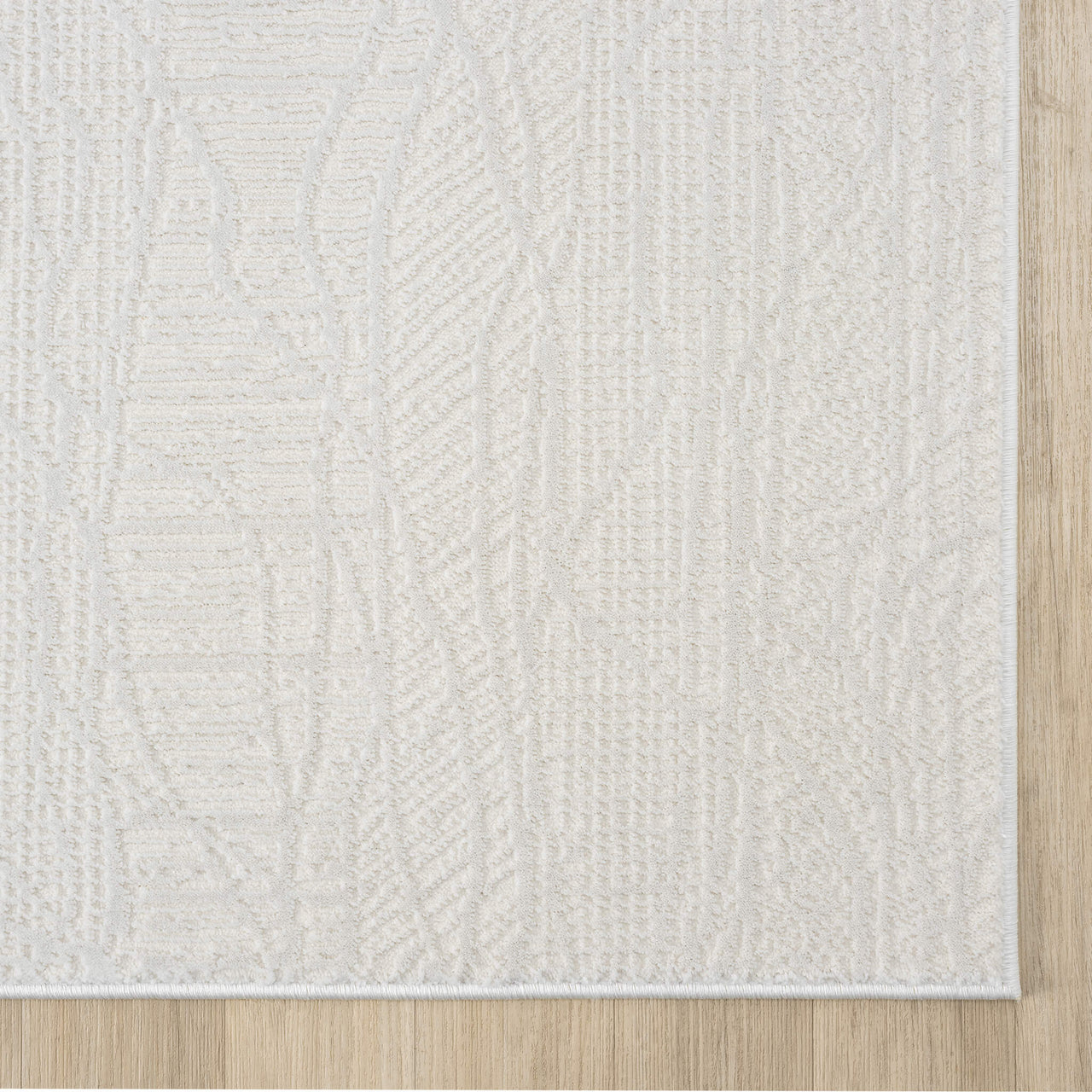 Cream modern rug with subtle geometric pattern and textured weave on light wood floor.