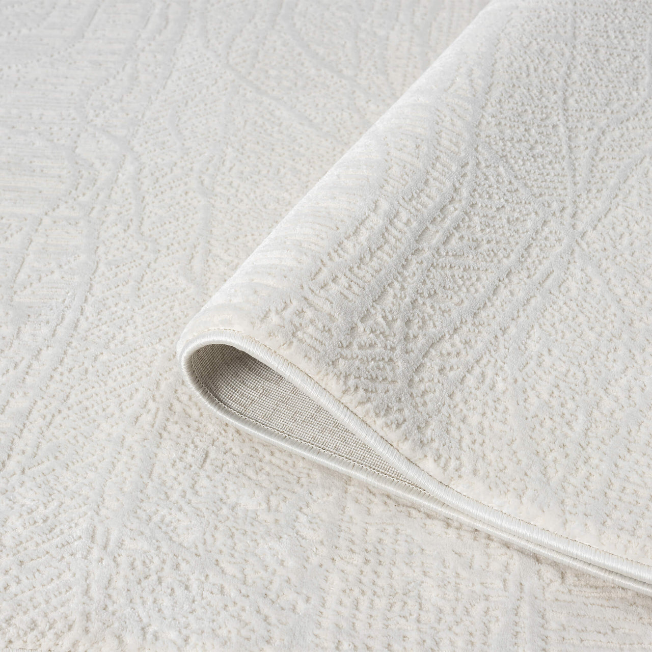 Cream modern rug with subtle geometric textured pattern, soft polyester-polypropylene blend.