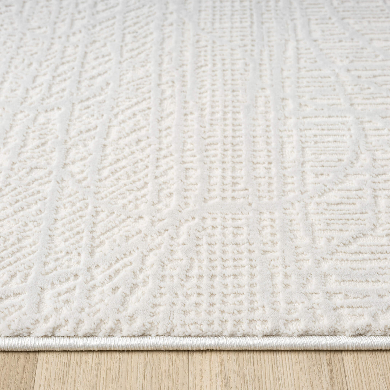 Cream modern rug with textured geometric patterns and soft, plush pile on wooden floor.