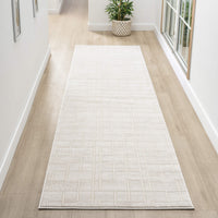 Cream modern runner rug with subtle textured geometric pattern on light hardwood floor in bright hallway.