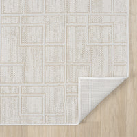 Cream modern runner rug with geometric square pattern and textured weave on light wood floor, corner folded to show backing.