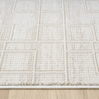 Cream runner rug with textured geometric square pattern on wooden floor.