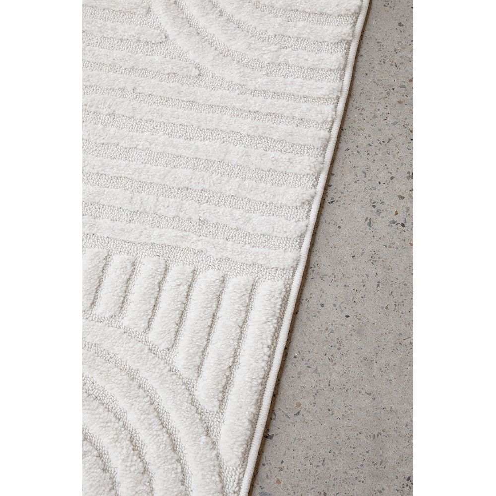Textured white rug on a concrete floor