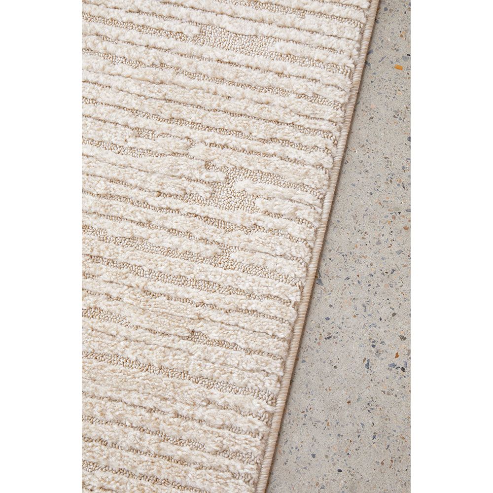 Textured beige rug on a concrete floor