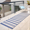 Blue and white striped runner rug on a patio with a chair and cushion.
