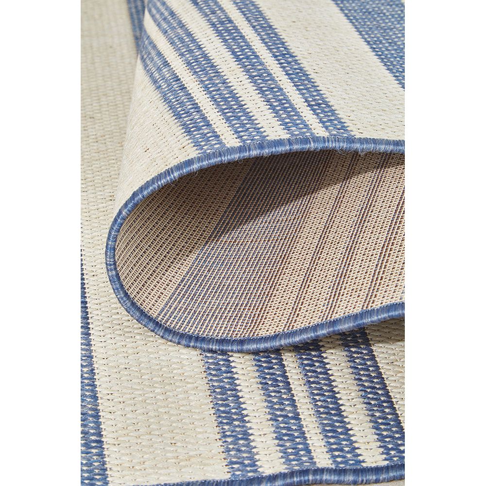 Close-up of a blue and beige striped rug with a textured pattern.