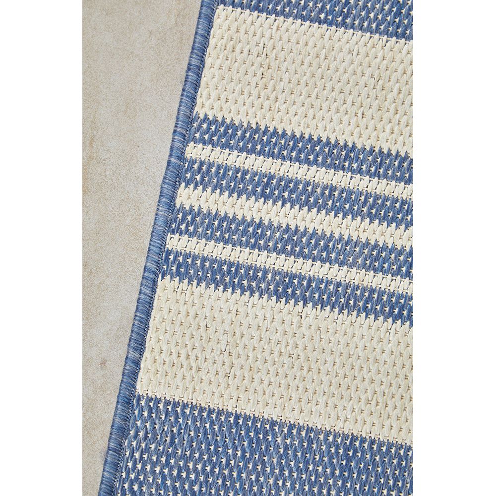 Close-up of a blue and beige striped rug on a neutral background