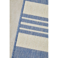 Close-up of a blue and beige striped rug on a neutral background