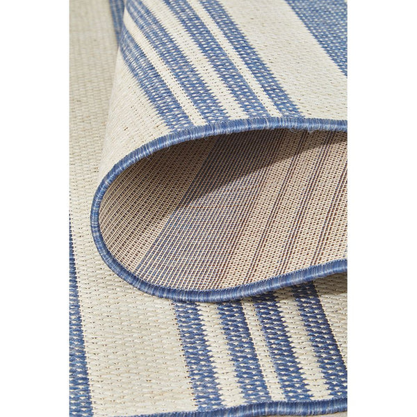 Close-up of a blue and beige striped rug with a textured pattern.