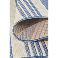 Close-up of a blue and beige striped rug with a textured pattern.