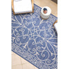 Blue and white patterned outdoor rug on a tiled floor.