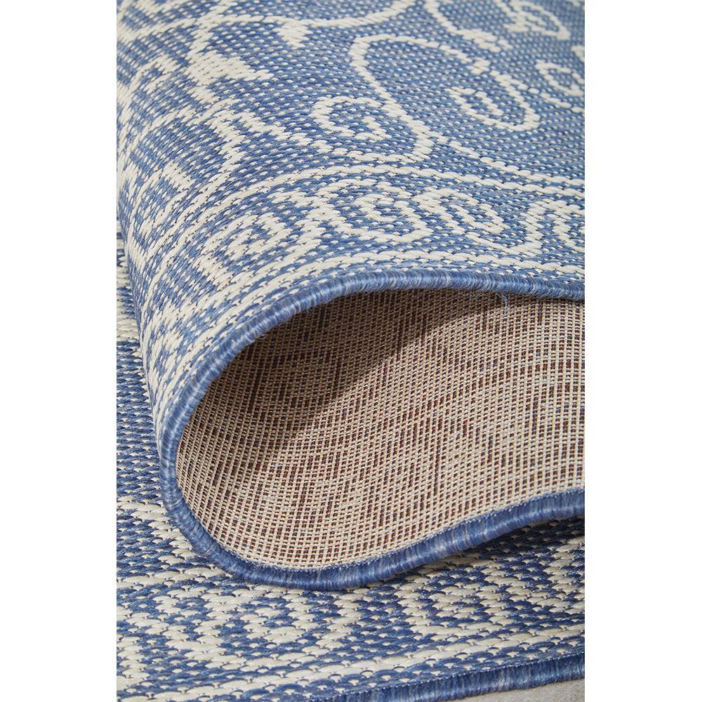 Close-up of a blue and beige patterned outdoor rug with a textured border.