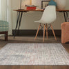 Beige abstract patterned rug with subtle multi-colored accents in a modern room setting.