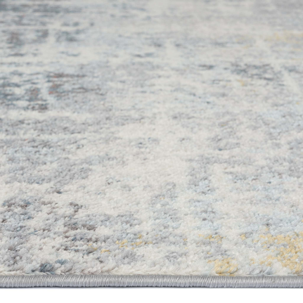 Grey multi-colored abstract patterned runner rug with subtle blue and yellow accents.
