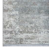 Grey rug with white and blue abstract pattern and subtle textured design.