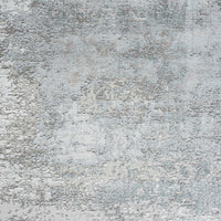 Grey and white abstract patterned modern rug with subtle blue accents and textured surface.