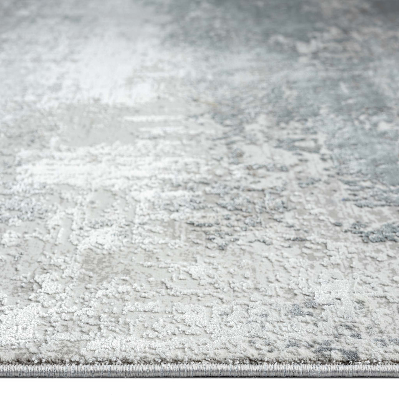 Grey and white abstract patterned modern rug with subtle blue accents and soft texture.