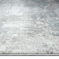 Grey and white abstract patterned modern rug with subtle blue accents and soft texture.