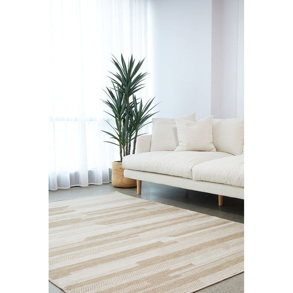 Natural cream flatweave rug with subtle striped pattern in a modern living room setting.