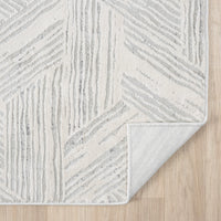 Light grey runner rug with geometric textured pattern and neutral tones on hardwood floor.
