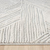 Light grey modern runner rug with raised geometric textured pattern and soft pile on wood floor.