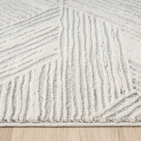 Light grey modern runner rug with raised geometric textured pattern and soft pile on wood floor.