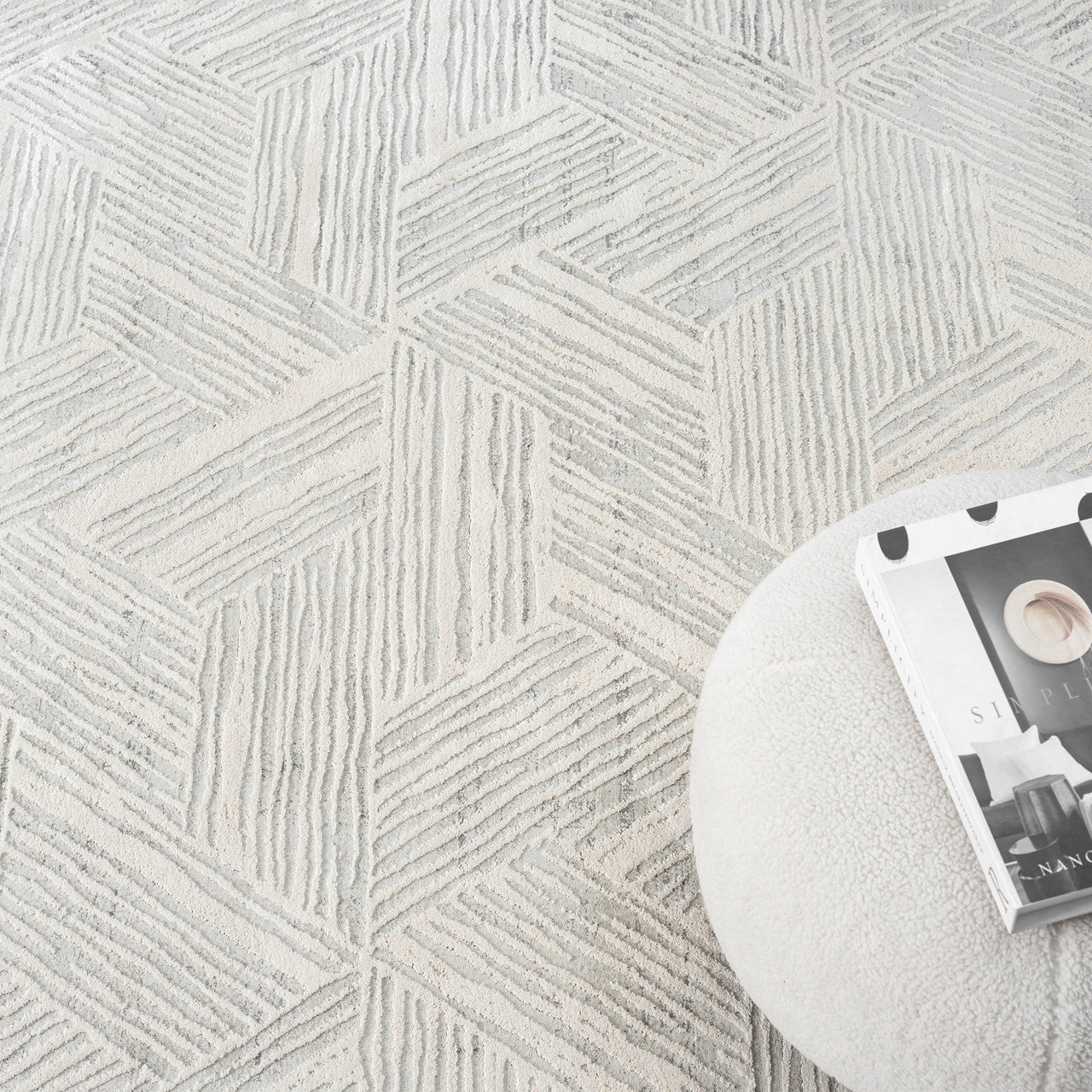 Light grey modern rug with geometric hexagon pattern and textured pile detail.