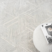 Light grey modern rug with geometric hexagon pattern and textured pile detail.