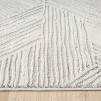 Light grey modern rug with geometric textured patterns and raised pile on neutral background.
