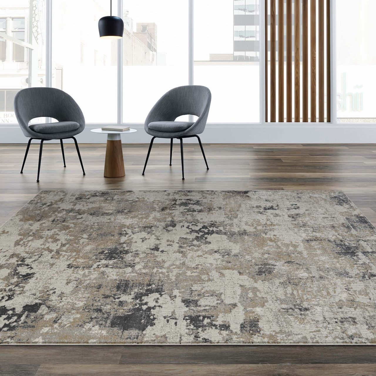 Grey multi-color abstract textured rug with neutral tones and modern pattern on wood floor.