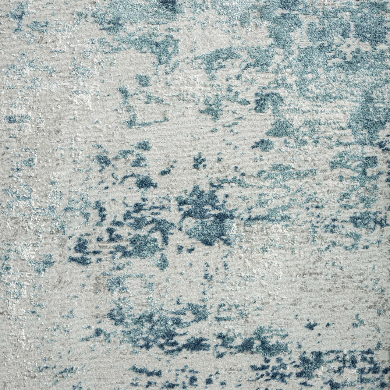 Blue and beige textured abstract modern rug with a distressed, multi-tonal pattern.